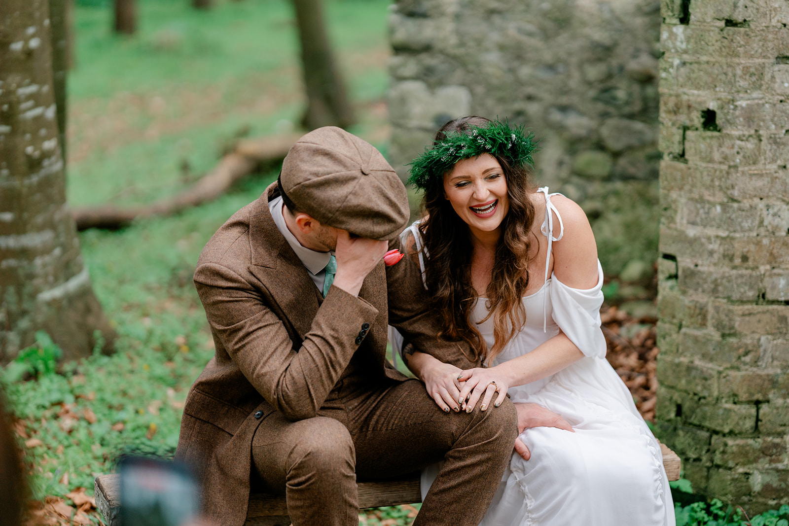 A couple laughing together on a bench in the Killyon woods