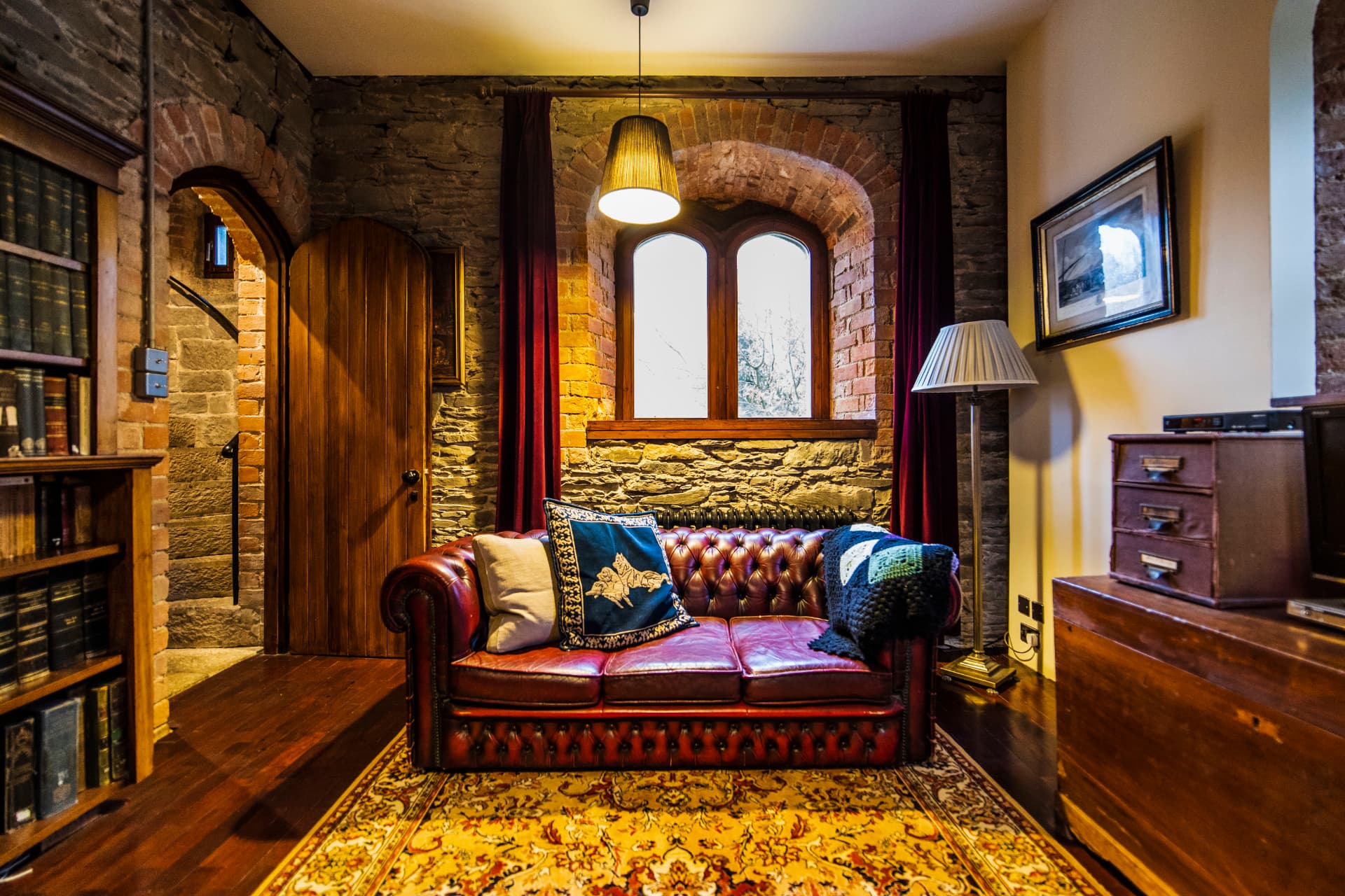 A cosy sitting room with original stonework and deep leather seating at Drummond Tower