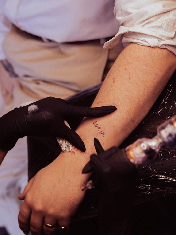 A matching tattoo being inked at Heartbreak Chapel