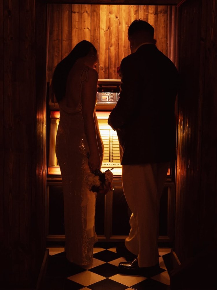 A couple choosing a song at the Heartbreak Chapel jukebox